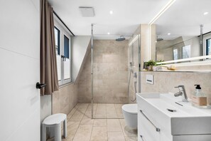 Ein modernes Badezimmer mit Dusche, Toilette und Waschtisch.