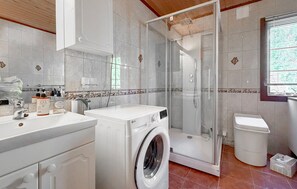A modern bathroom with a washing machine, a glass shower enclosure, and a toilet. - 2 bedroom gorgeous home in årjäng (Årjäng)