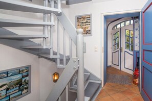 Eine Treppe mit Handlauf und einer Wandleuchte.