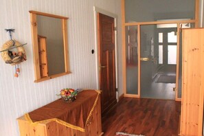 A room with a wooden table, a mirror, and a door leading to another room. - Holiday apartment with 1 bedroom (Rhinow OT Kietz)