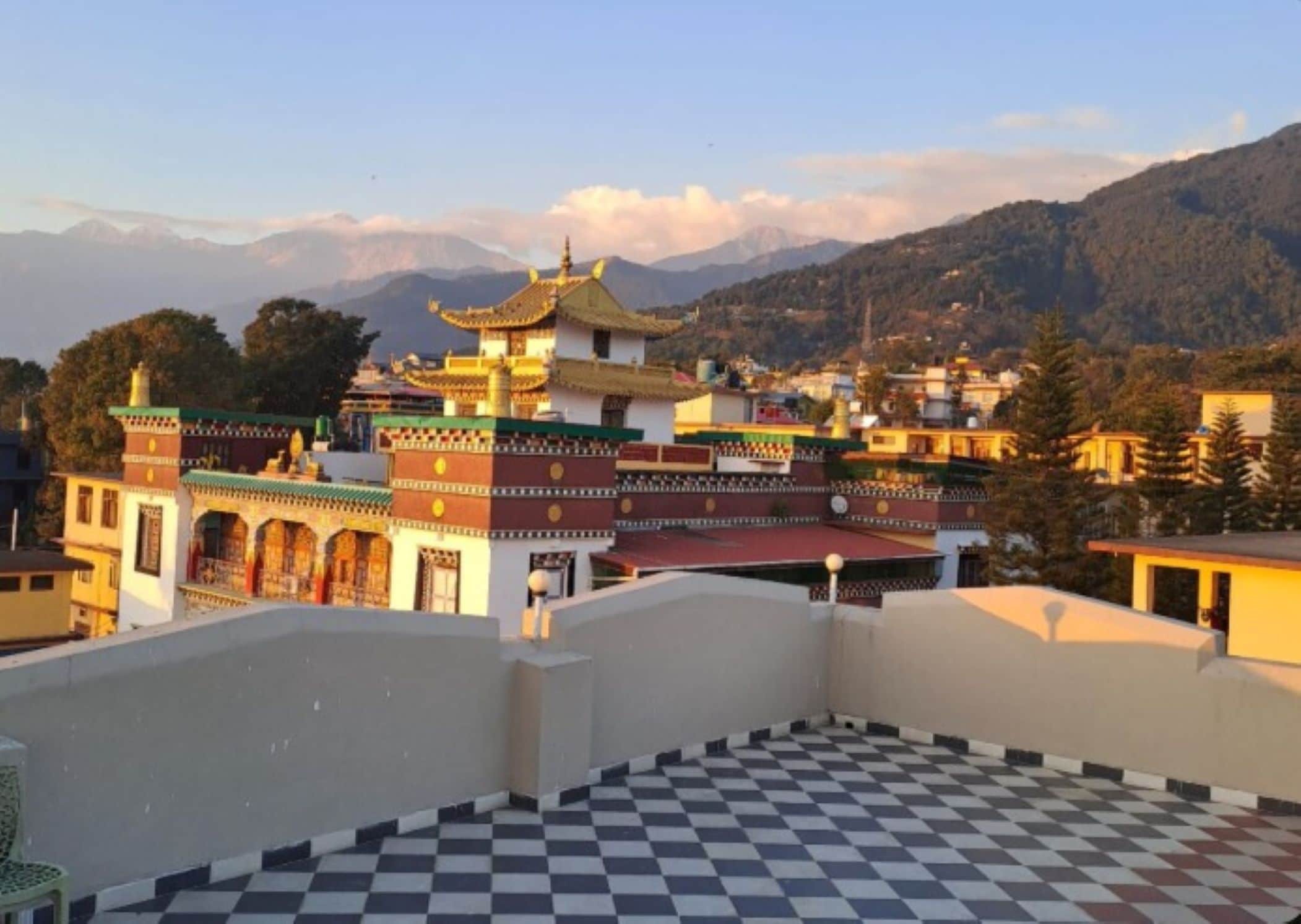 A traditional building with a multi-tiered roof, surrounded by a mountainous landscape.