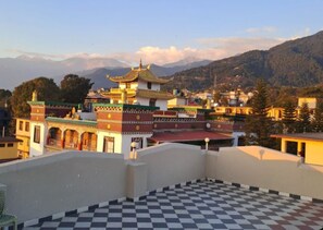 Un edificio tradicional con un tejado escalonado, rodeado de un paisaje montañoso.