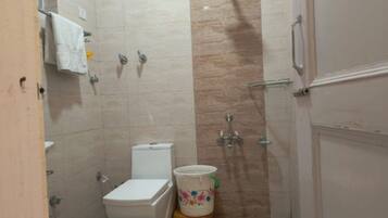 Un baño pequeño con inodoro, ducha y lavamanos.