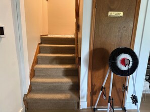 A carpeted staircase leading to a door labeled 'STORAGE ROOM' with a sign indicating 'Authorized Personnel Only.' - Luxury Chalet on 1.5 Acres: Mountain Views, Hot Tub, Gym, fire pit & Ping-Pong (Windham)