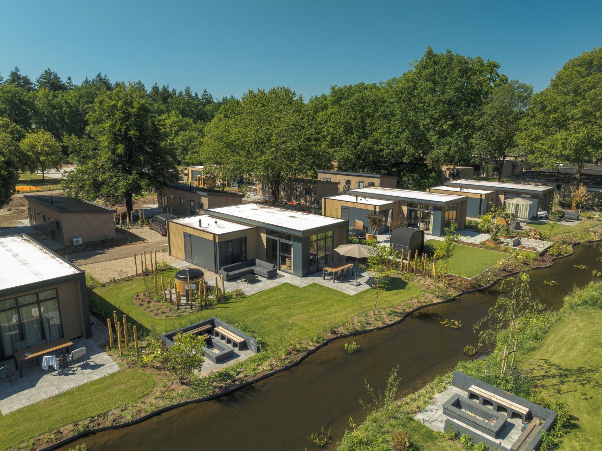 Un complejo residencial moderno con varias casas, un patio central y un pequeño canal.