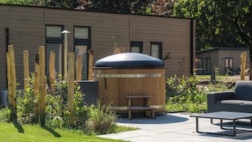 Ein moderner Sitzbereich im Freien mit Holzkonstruktion, einer Bank und einem Tisch.