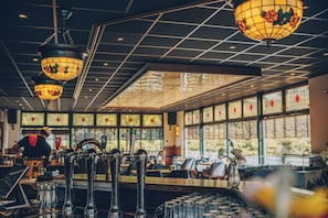 Zona de bar con varias griferías, una barra y techo con diseño de cuadrícula.