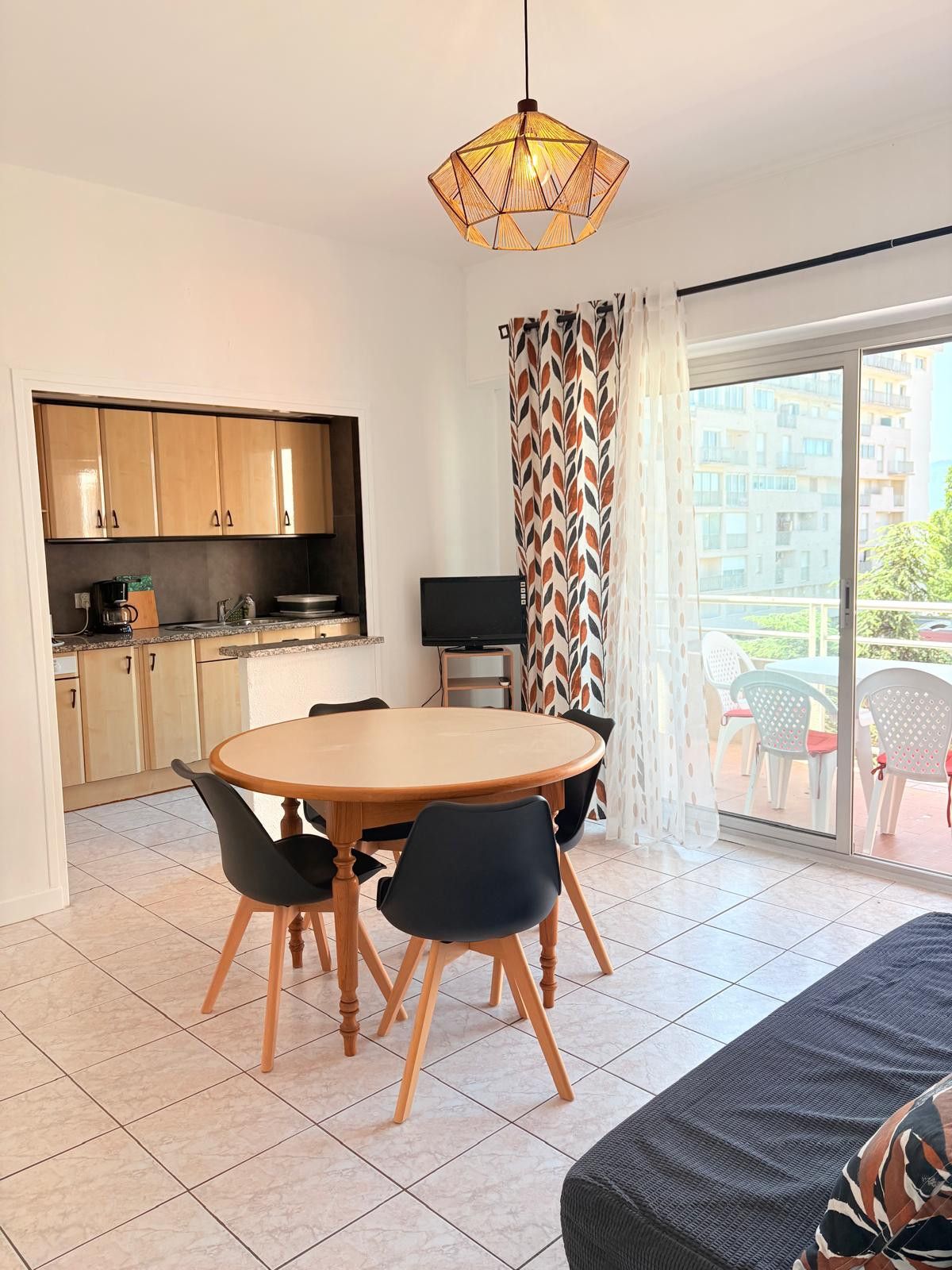 A compact living space with a kitchen, dining area, and a balcony with a view.