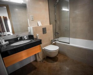 Un baño con lavamanos, inodoro y bañera.