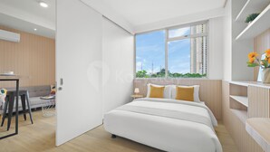 Quarto moderno com uma cama grande, uma escrivaninha e uma janela com vista para a cidade.