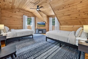 A cozy bedroom with two beds, a ceiling fan, and a large window. - Hothouse Creek Retreat - Fishing Access, Firepit & Large Outdoor Space (Mineral Bluff)