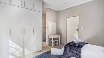 Une chambre à coucher avec un lit, un bureau et une armoire.