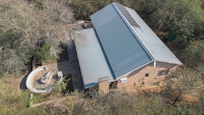 A single-story building with a flat roof, surrounded by trees and vegetation. - Kruger Villa - Where Luxury Meets Nature (Nkomazi)