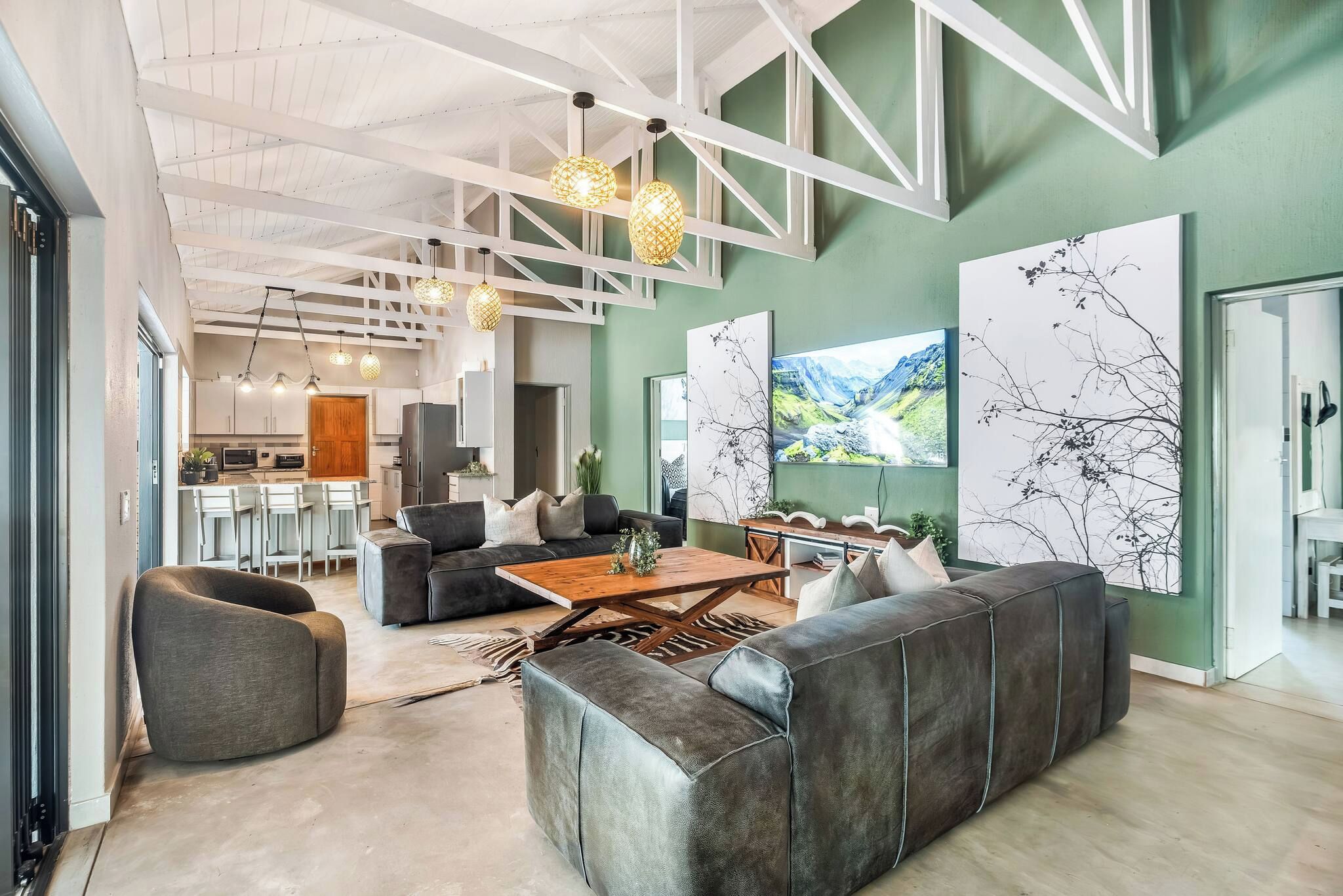 A modern interior with a living area featuring a sofa, coffee table, and pendant lighting.