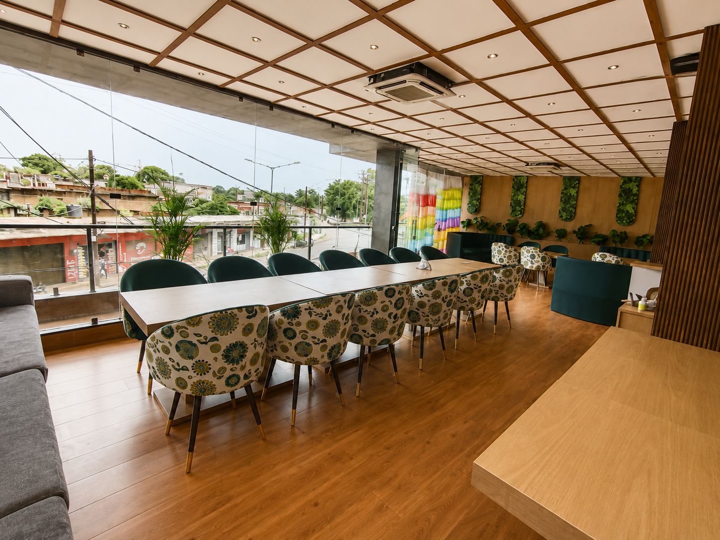 Un salón de conferencias con una larga mesa y sillas, ventanas amplias y vistas al exterior.
