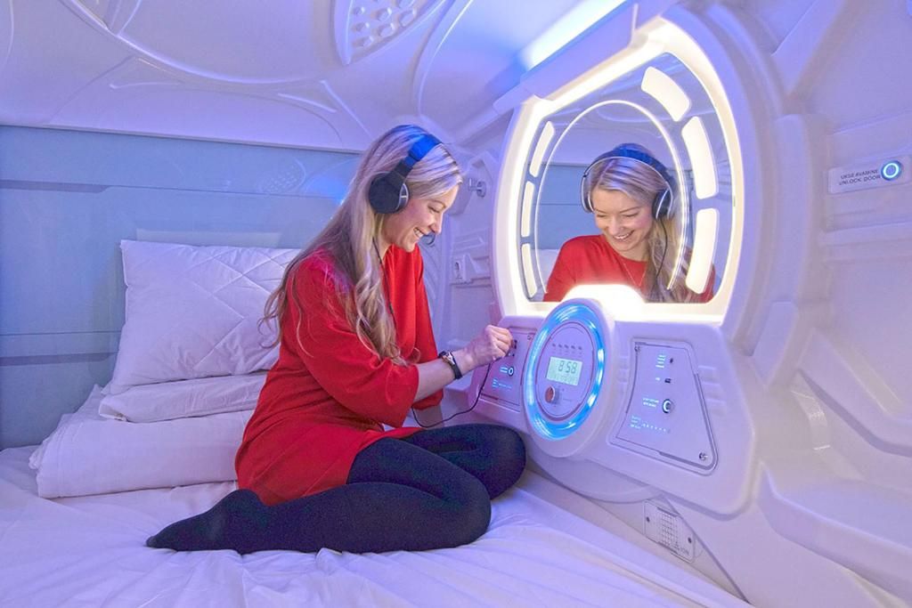 A person sitting on a bed in a room with a massage therapy machine.