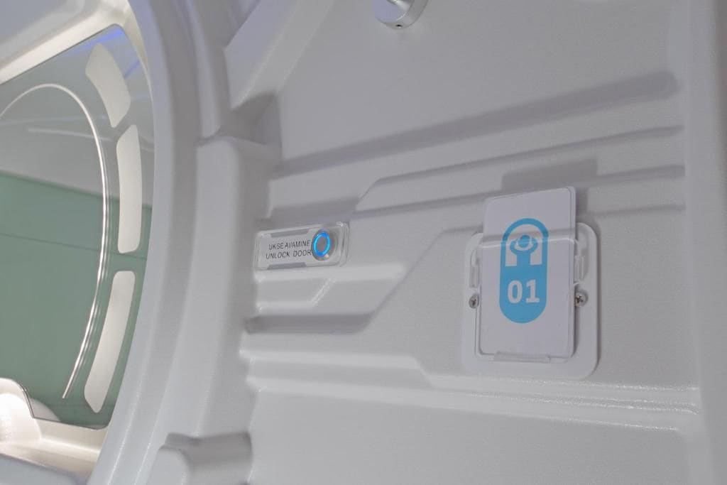 A white interior wall with a door handle and a blue lock symbol indicating a secure area.