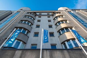 Un edificio con varias ventanas y dos banderas, una que dice 'TALLINN' y la otra 'HOBBY'.