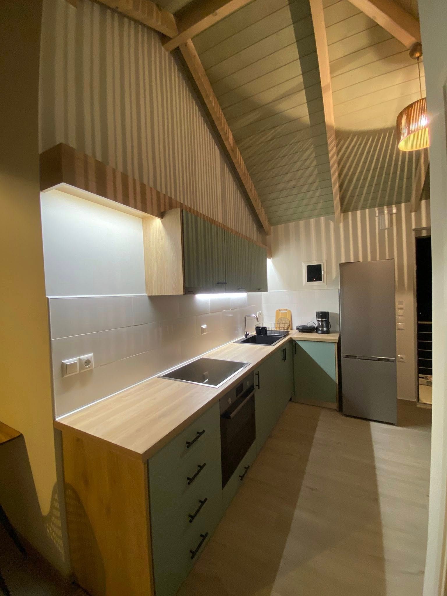 Una cocina compacta con estufa integrada, pileta y heladera.