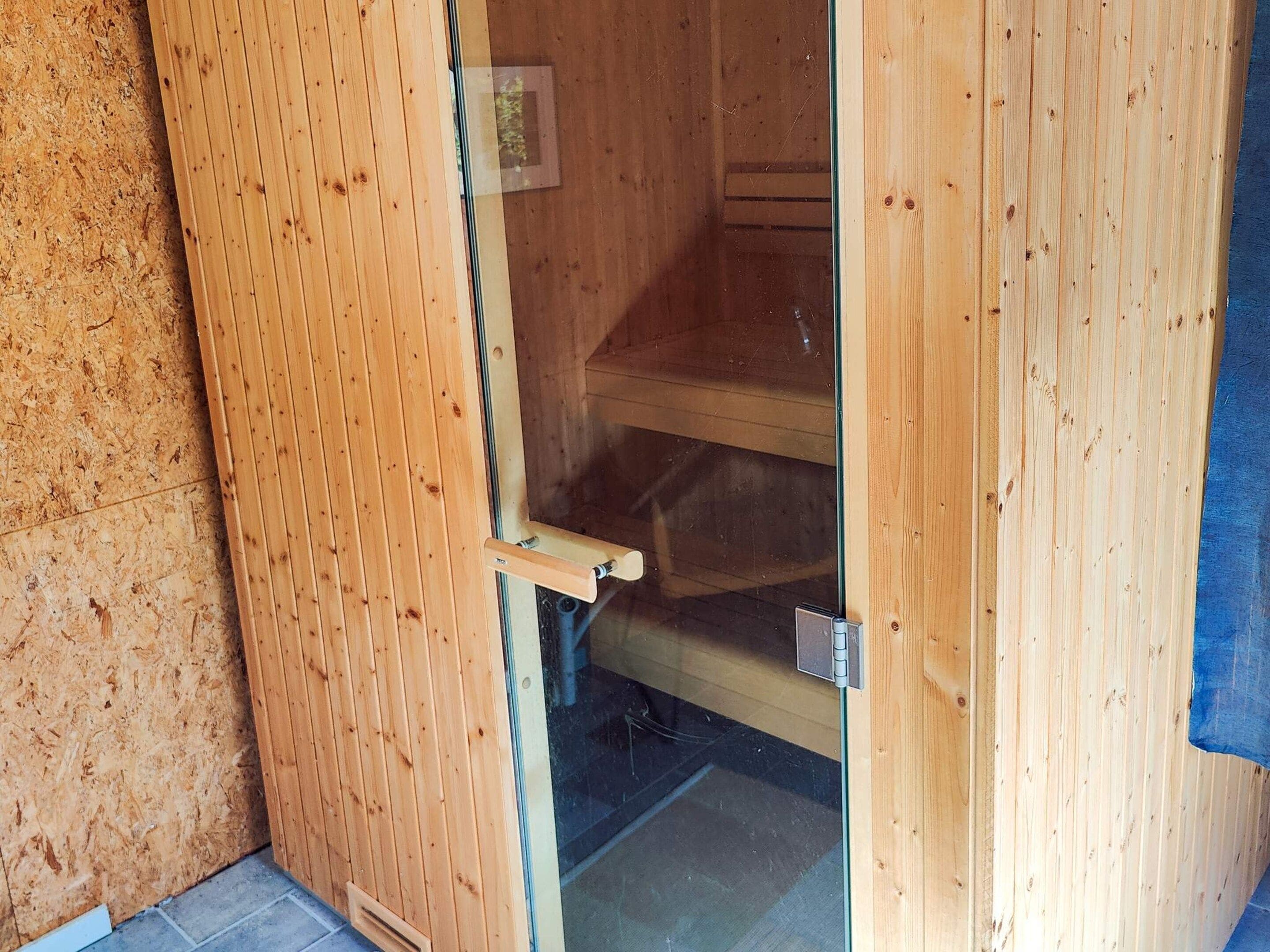 Une porte en bois avec une poignée, un loquet en métal et un panneau de verre.