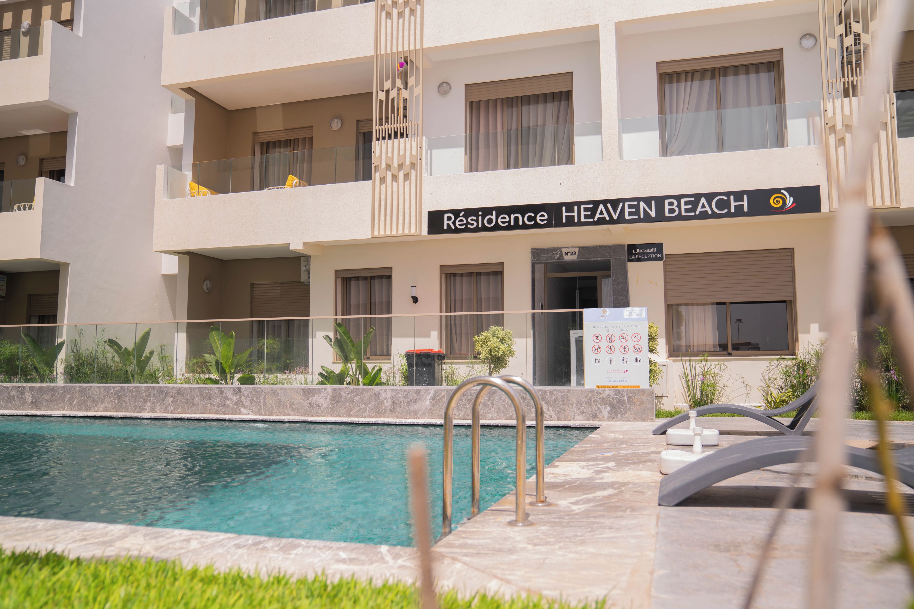 Ein Hotel namens 'Residence Heaven Beach' mit Swimmingpool, Außenbereich und einer Rezeption.