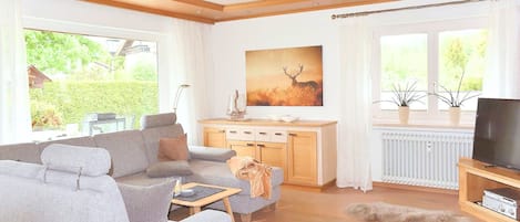 Un salon avec un canapé, une table basse et un téléviseur.