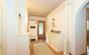 A hallway with white walls, wooden flooring, and a white door at the end. - Lacus Apartment by Loewenherz (Krün)