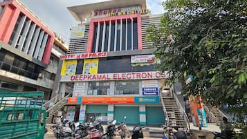 Ein mehrstöckiges Gebäude mit verschiedenen Geschäften, darunter ein Hotel, ein Elektronikladen und eine Bank.