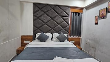 Ein schmaler Raum mit einem Bett, einer Kopfteil und einem Fenster mit Vorhängen.