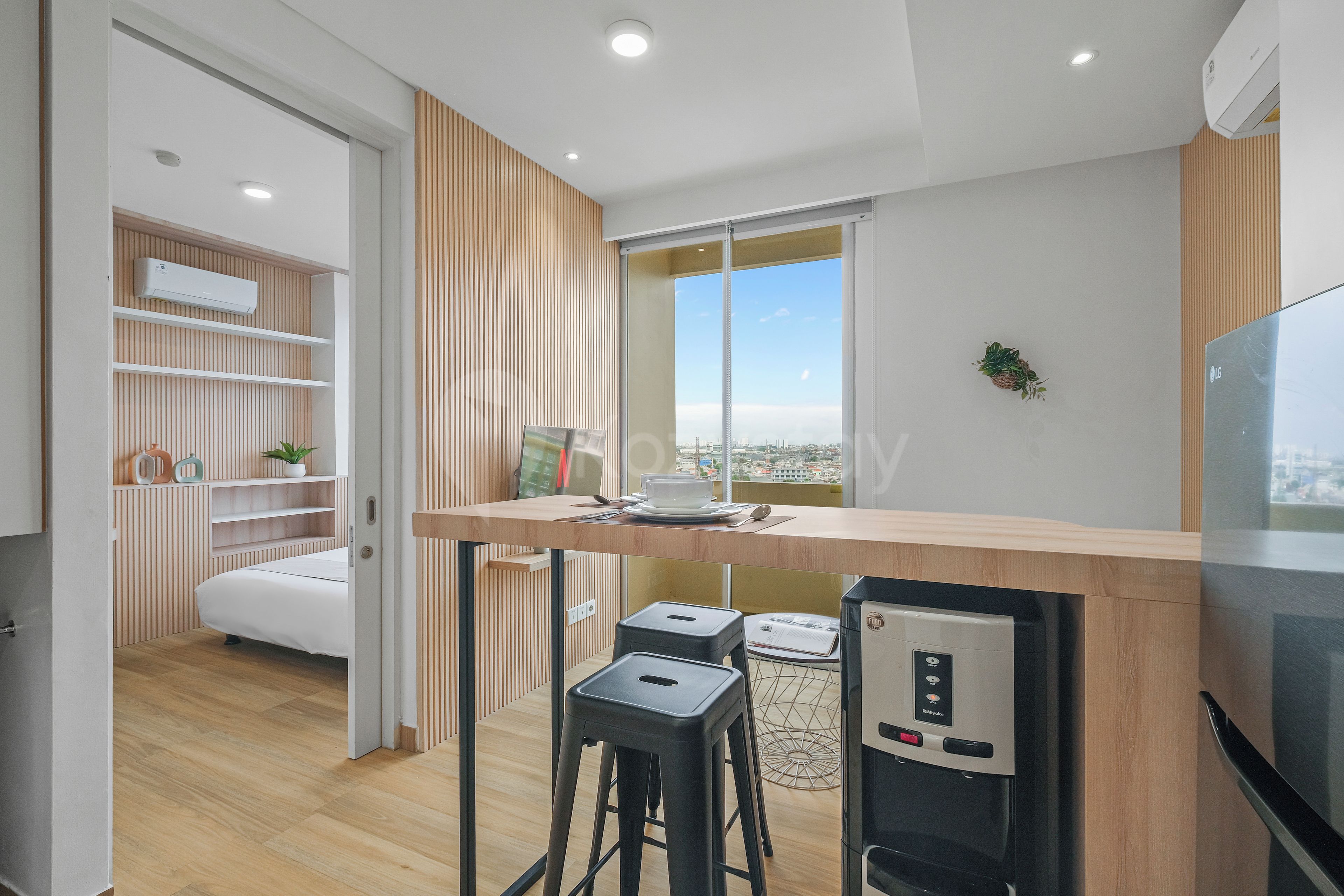 A modern kitchen with a dining area, a built-in air conditioner, and a view of the city.