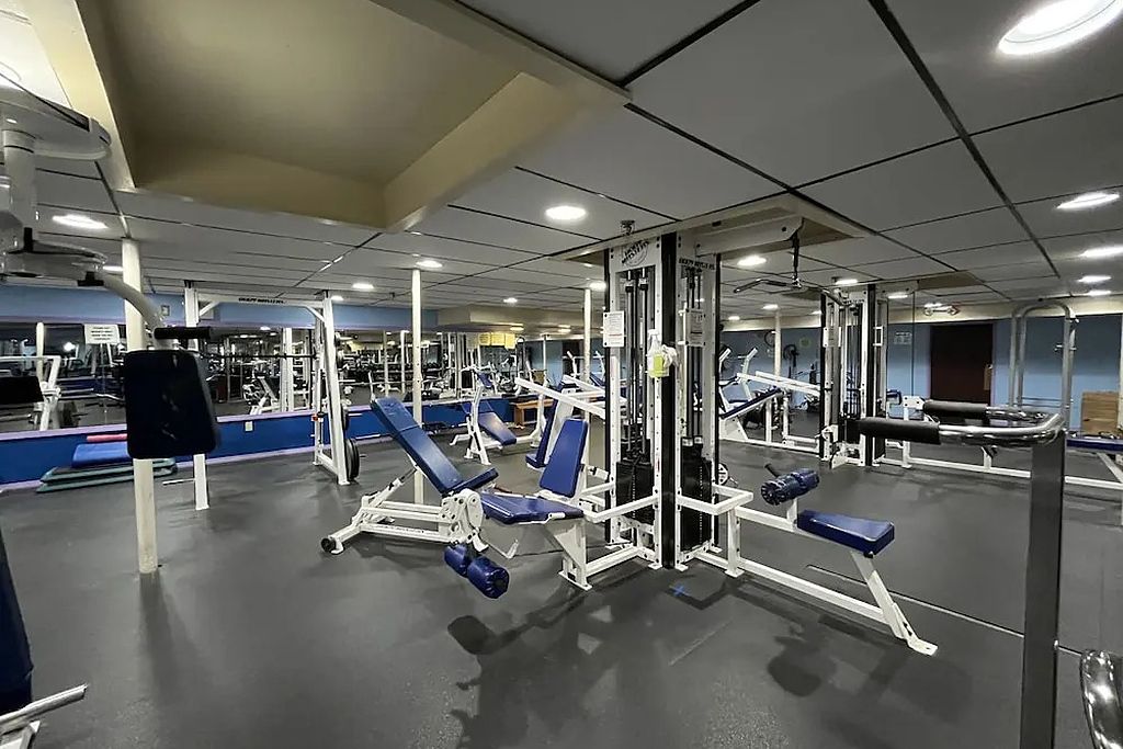 A gym with various exercise equipment, including weight machines and benches.