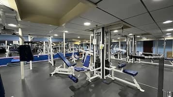 A gym with various exercise equipment, including weight machines and benches.