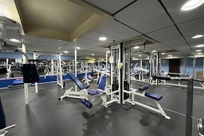A gym with various exercise equipment, including weight machines and benches.