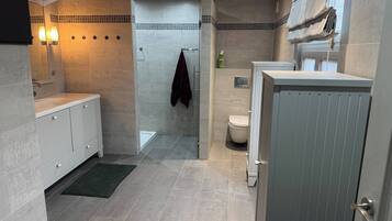 A modern bathroom with a shower, toilet, and vanity.
