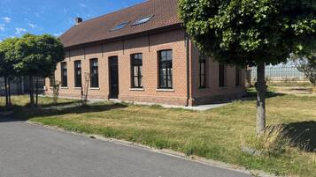 A brick building with a flat roof, multiple windows, and a paved driveway.