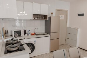 Una cocina compacta con estufa integrada, microondas y pileta.