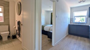 Et moderne badeværelse med toilet, vask og spejl.