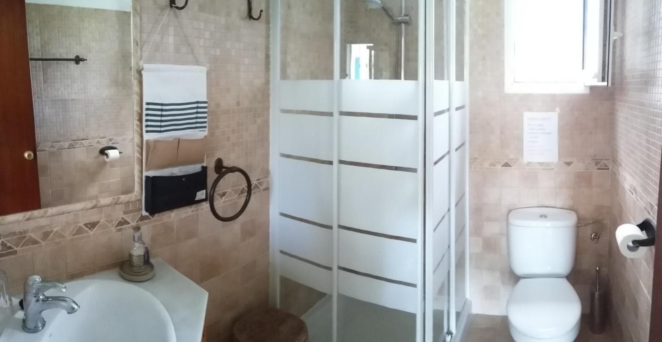 A bathroom with a shower, toilet, and sink.