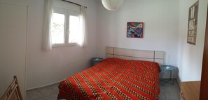 A bedroom with a bed, a window, a bedside table, and a wall-mounted artwork. - Casa Montecote Playa – Beach House Near Caños de Meca & Trafalgar (Barbate)