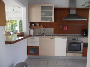 A kitchen with a stainless steel range hood, a dishwasher, and a built-in oven. - Casa Montecote Playa – Beach House Near Caños de Meca & Trafalgar (Barbate)