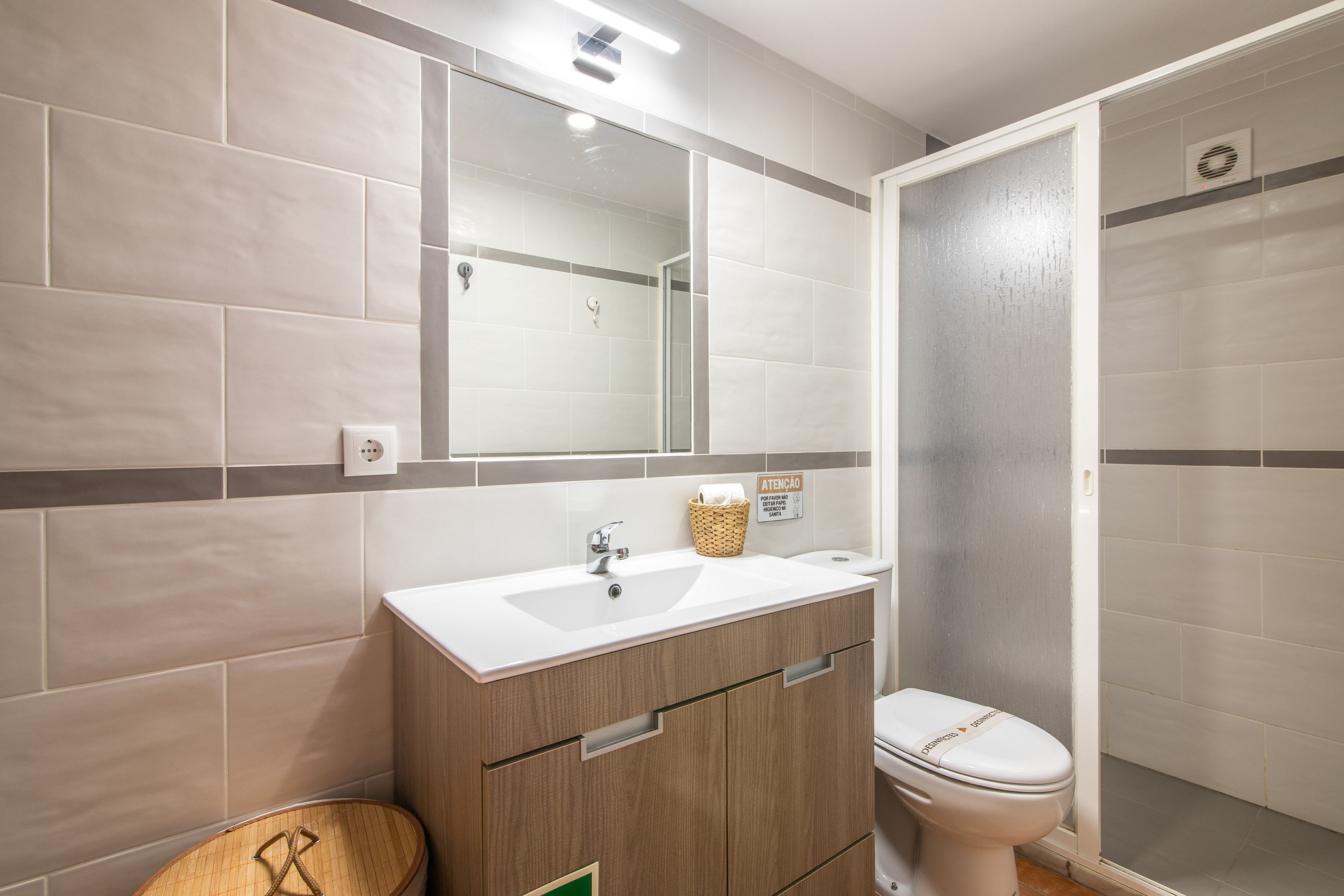 Een badkamer met een wastafel, spiegel en toilet.
