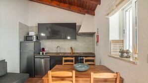 A compact kitchen with a dining area, featuring a microwave, a dishwasher, and a sink.