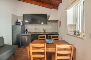 A compact kitchen with a dining area, featuring a microwave, a dishwasher, and a sink.