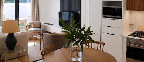 A modern kitchen with a microwave, oven, and a dining area with a round table and chairs.