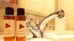 Deux bouteilles de shampoing et de gel douche TRIPALG sur le lavabo d’une salle de bain.
