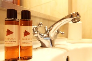 Dos botellas de champú y gel de ducha TRIPALG sobre un lavamanos de baño.