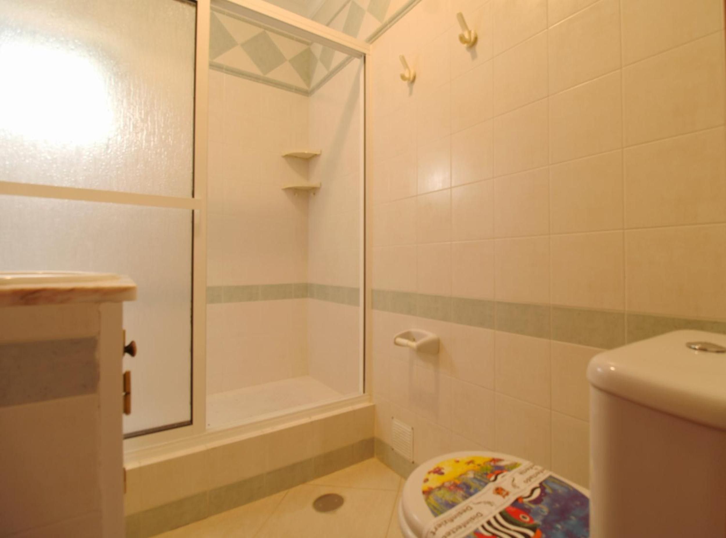 Un baño con ducha, inodoro y lavamanos.