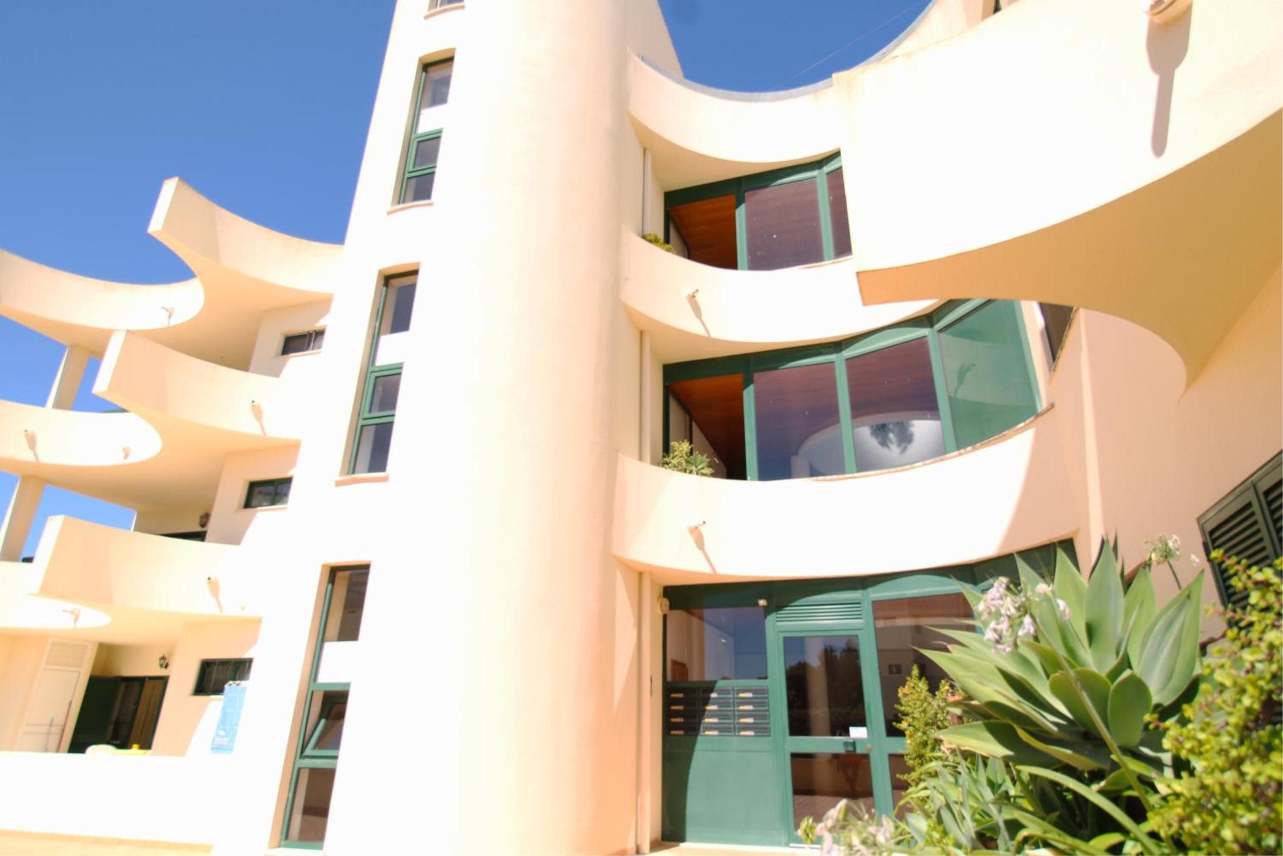 Un edificio de varios pisos con balcones y ventanas amplias.