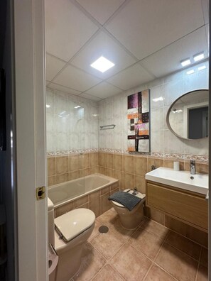 A bathroom with a toilet, sink, and bathtub. - Sea, comfort and tranquillity — right by the beach (Denia)