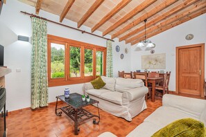 Un salon chaleureux avec un canapé, une table à manger et un plafond en bois.